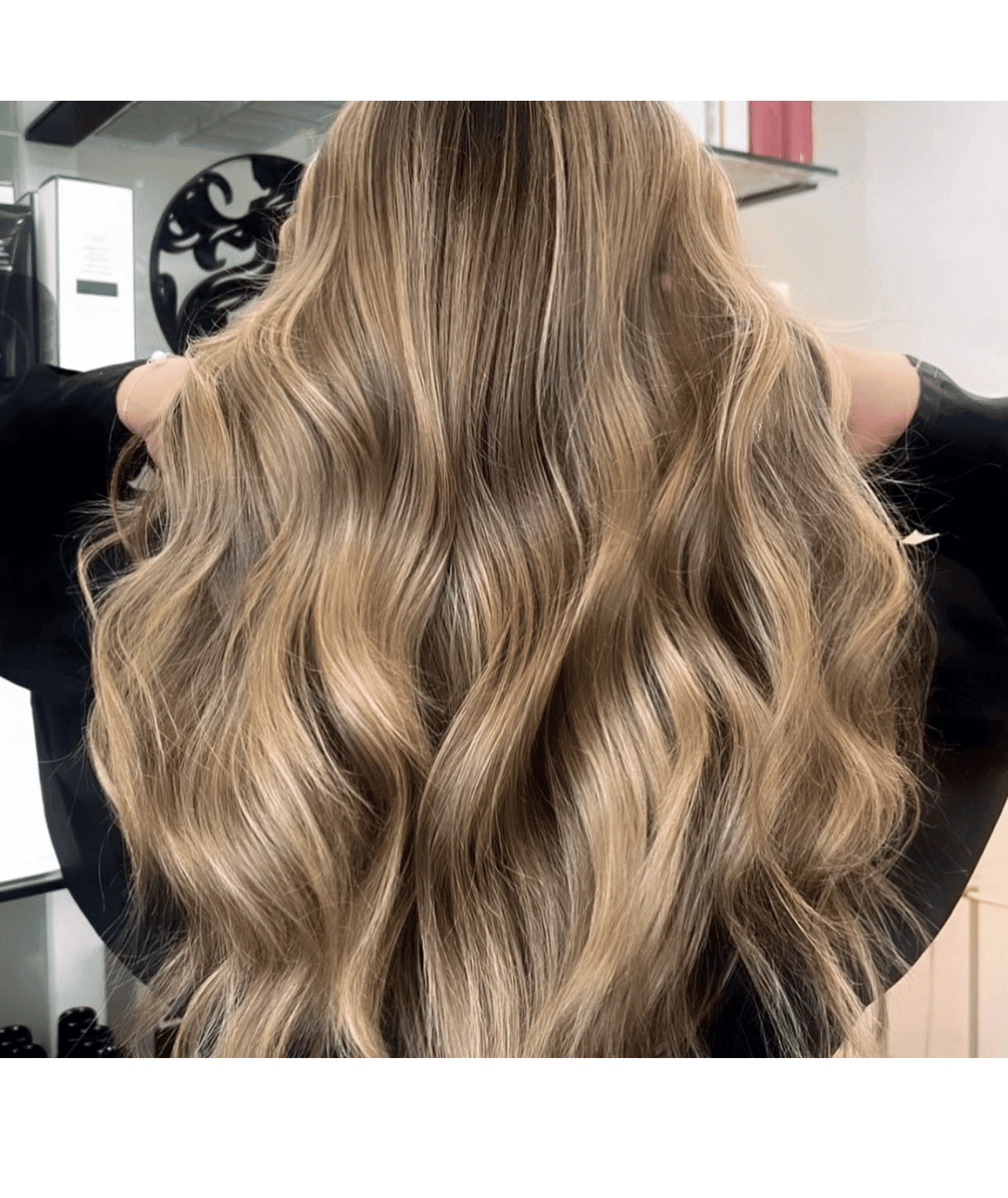 Long wavy blonde hair in a salon setting, styled to perfection.
